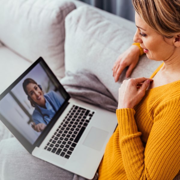 Woman in yellow shirt having a virtual visit with her medical provider